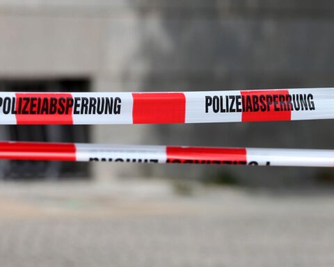 Polizeiabsperrung vor Mehrfamilienhaus, Symbolbild für Gewalt und Ermittlungen nach Messerangriff.