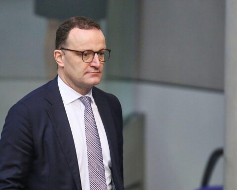 Jens Spahn vor dem Hintergrund des Berliner Regierungsgebäudes, symbolisiert politische Kontroversen und Rechtsprechung.