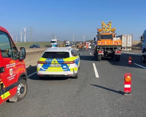 Schwerer Unfall auf Autobahn 7: beschädigter BMW, Trümmerfeld, Polizei und Feuerwehr im Einsatz.