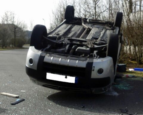 Verkehrsunfall mit zwei Fahrzeugen, Rettungskräfte vor Ort, verletzte Personen auf der Straße.