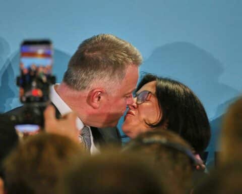 Wahlfeier der CDU in Rheinland-Pfalz: Mitglied jubelt über Wahlsieg, Ergebnisse in den Händen.