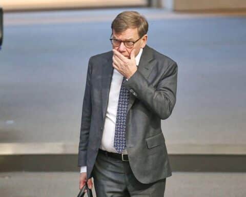 Politiker in Diskussion, Hintergrund Kriegsgeschehen, Iran, Israel, Fokus auf diplomatische Lösungen.