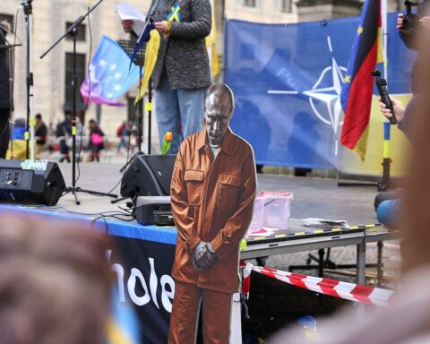 Pro-Ukraine-Demonstration in Berlin, Menschen halten Transparente und fordern Gerechtigkeit für Kriegsverbrechen.