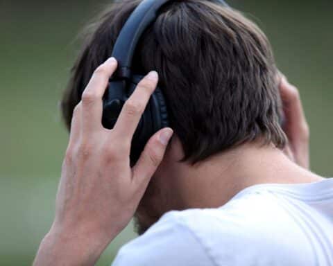 Mann mit Kopfhörern hört Musik, symbolisiert wichtige Diskussion über Streaming-Transparenz und fairen Verdienst.