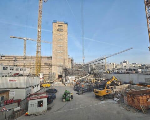 Stuttgart-21-Baustelle mit Wolken und Sonne, symbolisiert freundliches Wetter und kommende Temperaturen.