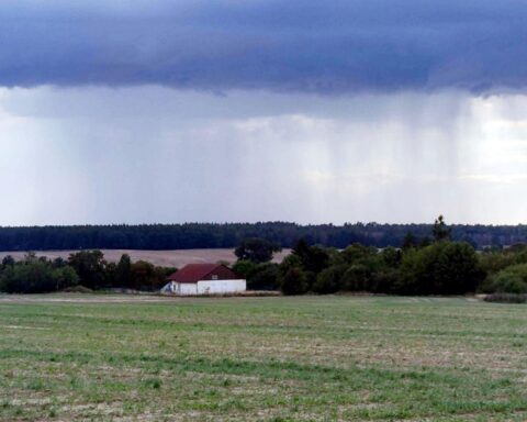 Dunkle Wolken über einem Acker, Regen und Schnee kündigen wechselhaftes Wetter an.