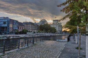 Sonnenuntergang über dem Reichstag, mit dichten Wolken und einem Hauch von Regenstimmung.