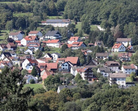 Helle Wohnhäuser im Hintergrund, strahlender Himmel, angenehme Temperaturen, ruhige Atmosphäre, sonniger Tag.