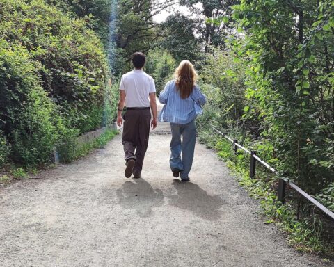 Mann und Frau genießen mildes Wetter beim Spaziergang unter heiterem Himmel.