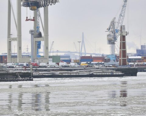Hamburger Hafen mit wechselndem Wetter, Wolken und milden Temperaturen, symbolisiert durch Hafenansicht.