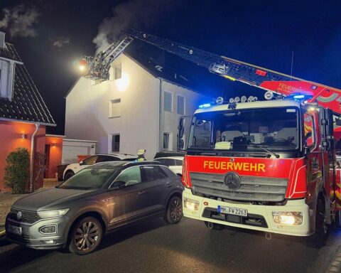 Feuerwehr löscht Zimmerbrand in Mülheim, alle Bewohner unverletzt, Einsatzkräfte vor Gebäude.