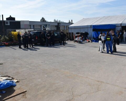 Zollbeamte kontrollieren chinesische Arbeiter in Lagerhalle, Verdacht auf illegale Beschäftigung in Deutschland.