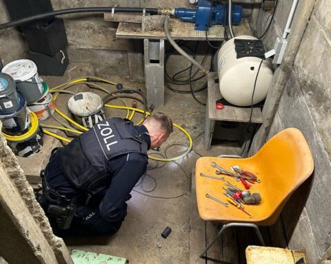 Zollbeamte durchsuchen Keller, Beweismittel sichern, Verdacht auf Schwarzarbeit und illegalen Aufenthalt.