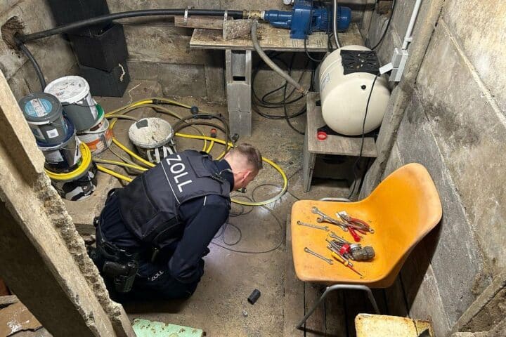 Zollbeamte durchsuchen Keller, Beweismittel sichern, Verdacht auf Schwarzarbeit und illegalen Aufenthalt.