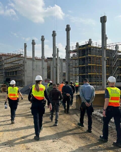 Zollbeamte kontrollieren Baustelle, überprüfen Arbeitgeber und identifizieren illegale Beschäftigung auf Bauprojekten.