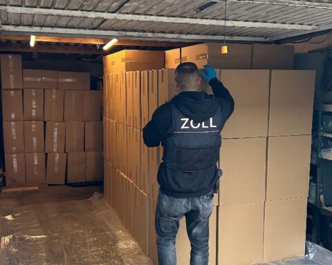 Durchsuchung von Wohnstätten, illegalen Zigaretten und Bargeld sichergestellt, Zollbeamte im Einsatz.