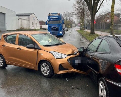 Zwei beschädigte Autos an der Straße, Rettungswagen und Polizei vor Ort nach Unfall.