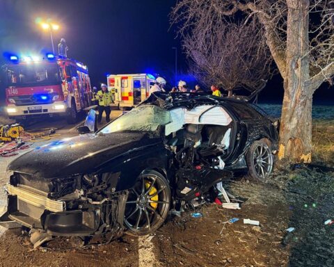 Ein schwer beschädigter Pkw, umgeben von Feuerwehr- und Rettungsfahrzeugen nach einem tragischen Unfall.