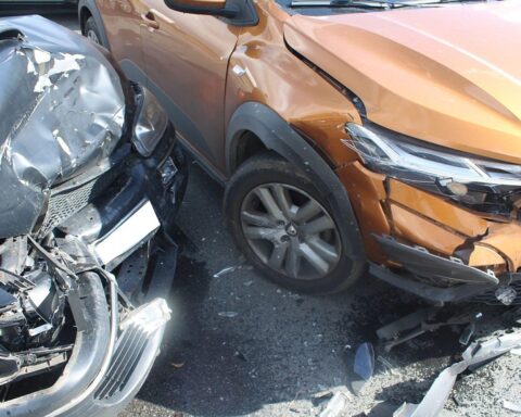 Zwei beschädigte Autos an einer Kreuzung, umgeben von Polizei und Absperrungen nach Unfall.