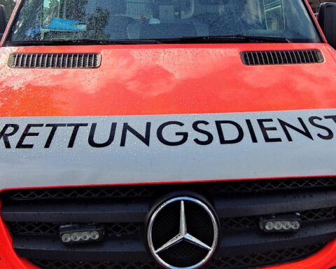 Ein Rettungswagen am Unfallort mit schwer verletztem Kleinkraftradfahrer und Polizeieinsatz.