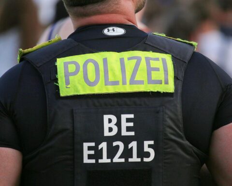 Schwarzer BMW und VW Golf nach Unfall auf Straße, Polizei und Feuerwehr im Einsatz.