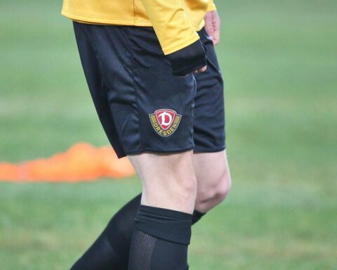 Dynamo-Spieler jubeln nach dem 2:0-Sieg; Atmosphäre überschattet von rivalisierenden Fangruppen.