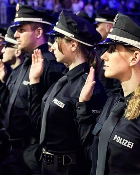 Polizeikommissaranwärter leisten feierlich ihren Diensteid in Anwesenheit von Politikern und Gästen.