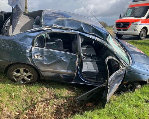 Ein zerstörter Toyota nach Unfall mit zwei Bäumen auf einer ländlichen Straße.