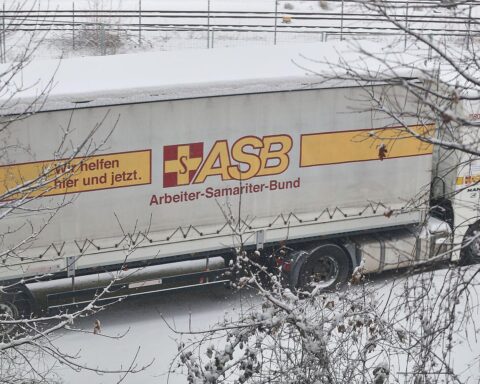 Protestierende Menschen halten Transparente gegen Kürzungen in der Kinder- und Jugendhilfe.