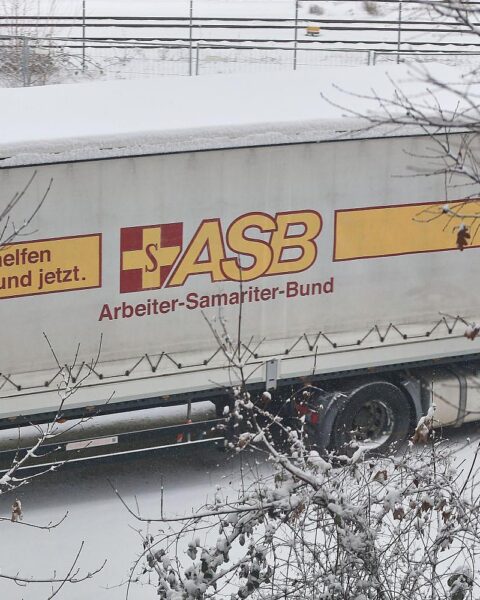 Protestierende Menschen halten Transparente gegen Kürzungen in der Kinder- und Jugendhilfe.