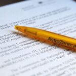 Vertragshandshake zwischen EU und AstraZeneca, symbolisiert Kooperation und Herausforderungen im Gesundheitssystem.