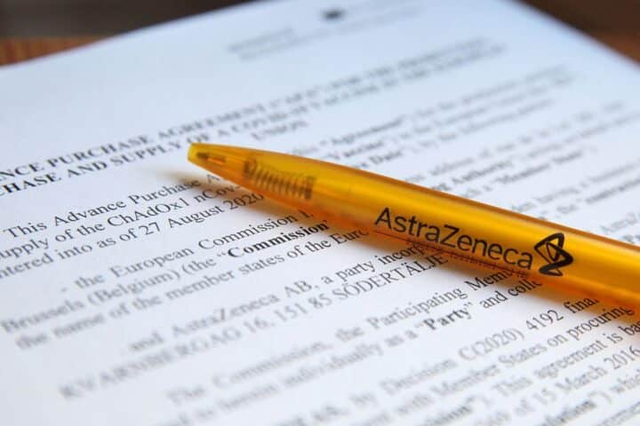 Vertragshandshake zwischen EU und AstraZeneca, symbolisiert Kooperation und Herausforderungen im Gesundheitssystem.
