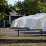 Flüchtlinge in einem Zeltlager, symbolisieren die aktuelle Debatte über Rückkehrmöglichkeiten nach Syrien.