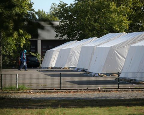 Flüchtlinge in einem Zeltlager, symbolisieren die aktuelle Debatte über Rückkehrmöglichkeiten nach Syrien.