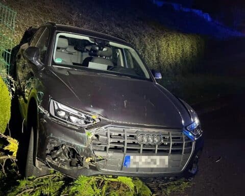 Ein verunfallter Audi, umgeben von Schäden und Zäunen, nach unkontrolliertem Abrollen.