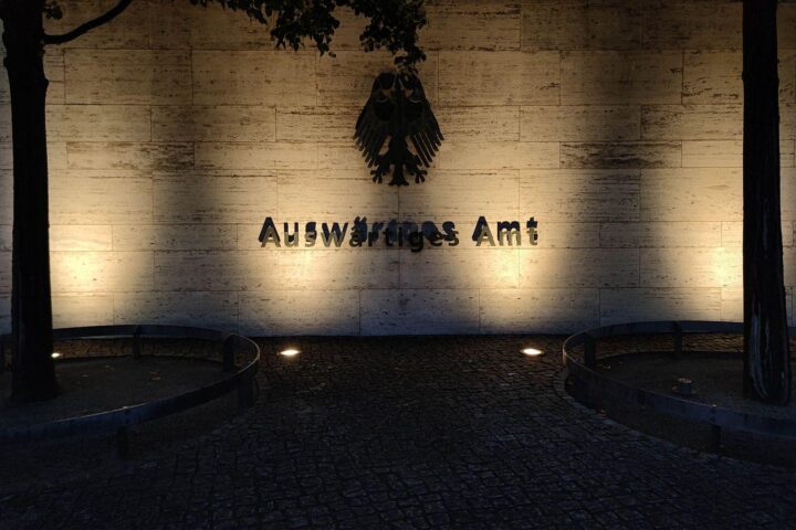 Mahnmal für NS-Opfer, Gerichtsurteile, deutsche und italienische Flaggen, Gerechtigkeit und rechtliche Auseinandersetzungen.