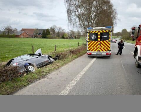 Unfallstelle mit Feuerwehr, Rettungsdienst und abgesperrter Straße, verletzter Autofahrer im Fahrzeug.