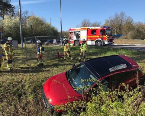 Ein verunfalltes Auto im Graben, Feuerwehrleute bei der Bergung, verletzter Fahrer.