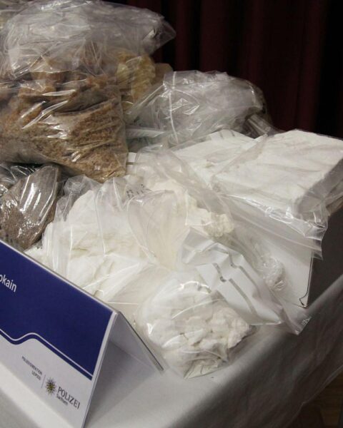 Kokainpakete, Polizei und Smugglers - eine Warnung vor steigender Drogenkriminalität in Deutschland.