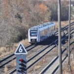 Regionalzug mit Preisanzeigen, um den Aufruf zur Preisreduzierung während der Spritpreiskrise zu verdeutlichen.