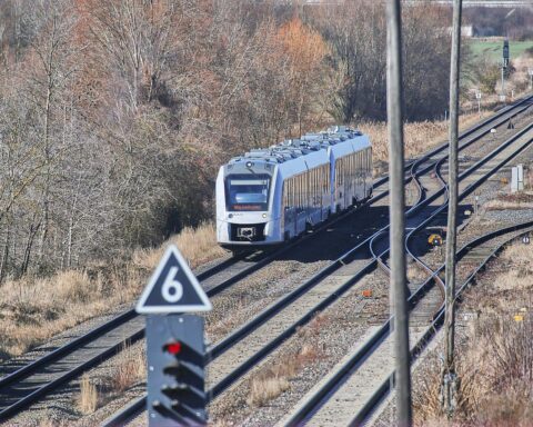 Regionalzug mit Preisanzeigen, um den Aufruf zur Preisreduzierung während der Spritpreiskrise zu verdeutlichen.