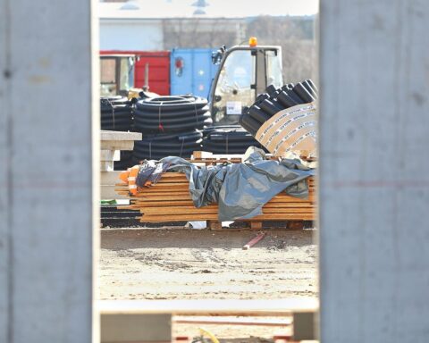 Baustelle mit Bauarbeitern und Maschinen, die Rückgänge und Fortschritte im Bauwesen symbolisiert.