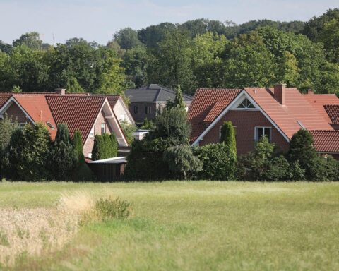 Grafik von bayerischen Stadtzuschüssen, Häusern und einem Diagramm zur Grundsteuererhöhung.