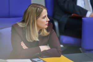 Verena Hubertz im Gespräch, umgeben von Sicherheitskräften, deutet auf Phishing-Bedrohungen innerhalb der Regierung hin.