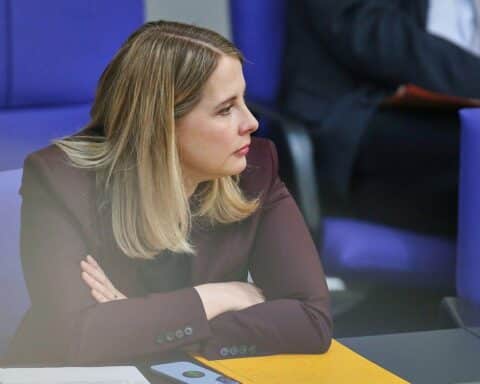 Verena Hubertz im Gespräch, umgeben von Sicherheitskräften, deutet auf Phishing-Bedrohungen innerhalb der Regierung hin.