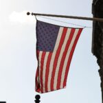 US-Flagge vor dramatischem Hintergrund, der den Absturz eines F-15E-Kampfflugzeugs symbolisiert.