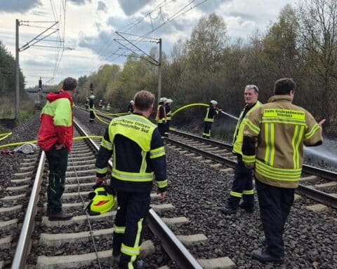 Führungskräfte und Förster bei Lagebesprechung während des Böschungsbrand-Einsatzes.