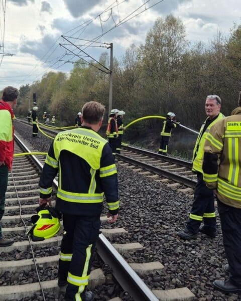 Führungskräfte und Förster bei Lagebesprechung während des Böschungsbrand-Einsatzes.