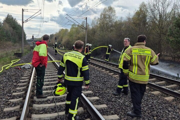 Führungskräfte und Förster bei Lagebesprechung während des Böschungsbrand-Einsatzes.