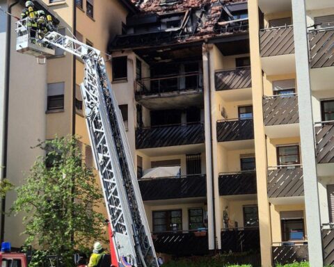 Evakuierte Bewohner, Feuerwehr im Einsatz, zerstörtes Mehrfamilienhaus nach Brand in Plochingen.